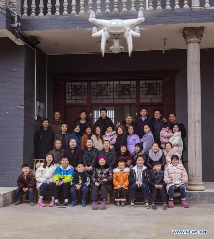 A household takes a selfie with a drone at a village in Longshan County of central China\'s Hunan Province, Feb. 15, 2018. Over the last few years, unmanned aerial vehicles (UAVs) have increasingly embedded in everyday life all around China. The duties of these civil drones range from agriculture, transportation to entertainment. The commercial sector relies on unmanned platforms for a variety of services, including aerial photography, crop monitoring, rescuing, delivering and performances. The wide use of drones not only makes life more convenient, but also broadens the imagination of Chinese people towards the coming future. (Xinhua/Tian Liangdong)