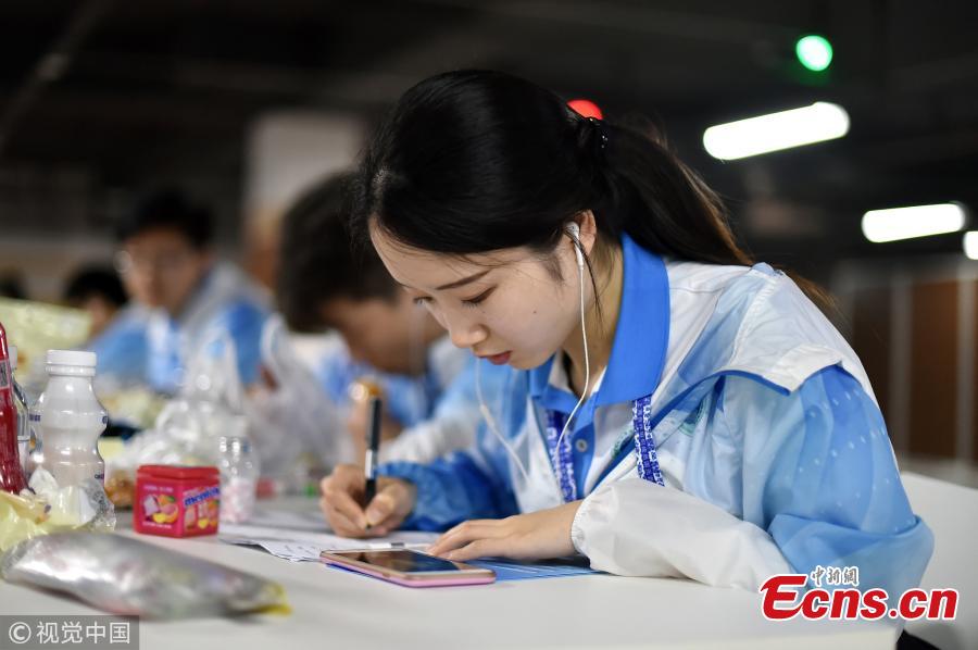 Volunteers work at the press center of the Shanghai Cooperation Organization Qingdao Summit in Qingdao City, East China’s Shandong Province, June 7, 2018. Some 370 volunteers from four universities in Qingdao are assisting journalists from home and abroad at the press center. (Photo/VCG)