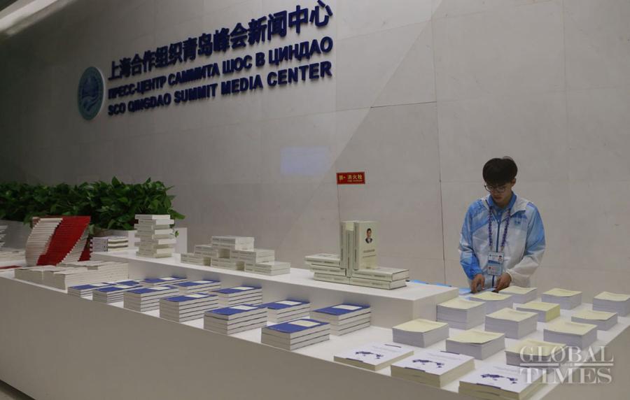 A volunteer sorts the books and materials related to the 2018 SCO summit at the media center for the 18th Shanghai Cooperation Organization Summit in Qingdao, East China\'s Shandong Province, on June 7, 2018. (Photo: Li Hao/GT)
