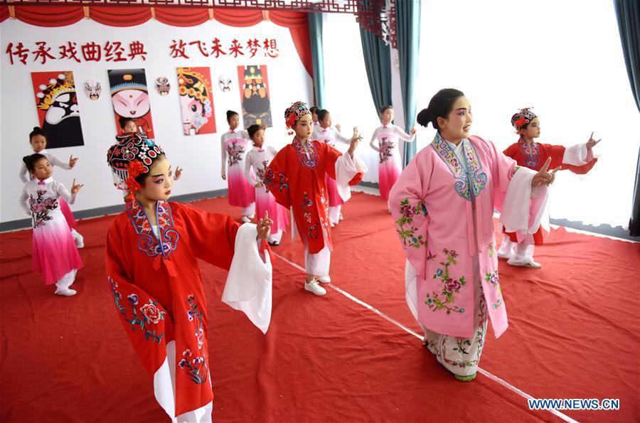 A teacher teaches students basic performing actions of Chinese drama at a primary school in Neiqiu County, north China\'s Hebei Province, June 8, 2018. The school introduced Chinese drama to student class to make it a way of inheriting traditional Chinese culture. (Xinhua/Zhu Xudong)