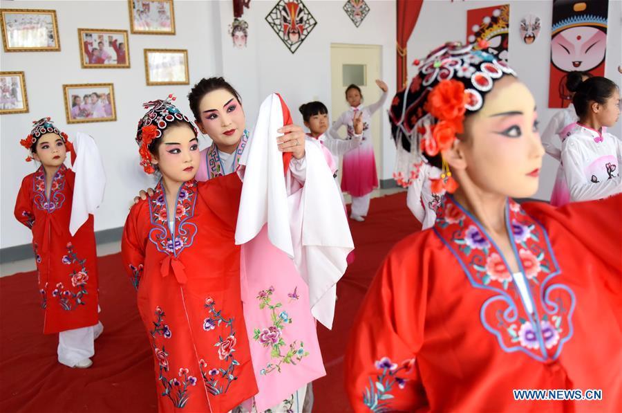 A teacher teaches students basic performing actions of Chinese drama at a primary school in Neiqiu County, north China\'s Hebei Province, June 8, 2018. The school introduced Chinese drama to student class to make it a way of inheriting traditional Chinese culture. (Xinhua/Zhu Xudong)