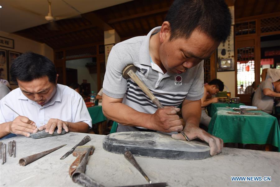 Inkstone amateurs compete in an inkstone carving contest in Wuyuan, east China\'s Jiangxi Province, June 9, 2018. Activities were held around China to celebrate the Cultural and Natural Heritage Day on Saturday. (Xinhua/Song Zhenping)