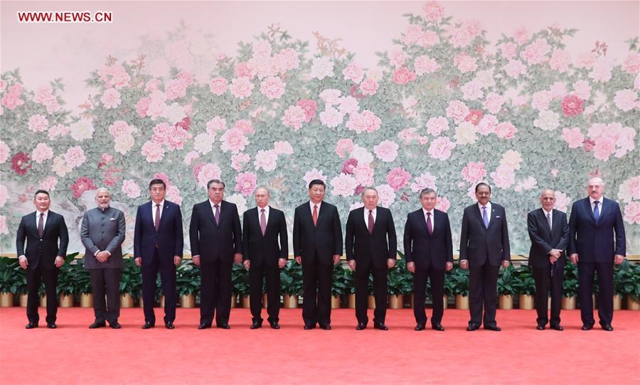 Chinese President Xi Jinping (C) and other leaders attending the 18th Shanghai Cooperation Organization (SCO) summit pose for a group photo ahead of a banquet in Qingdao, east China\'s Shandong Province, June 9, 2018. (Xinhua/Ding Lin)