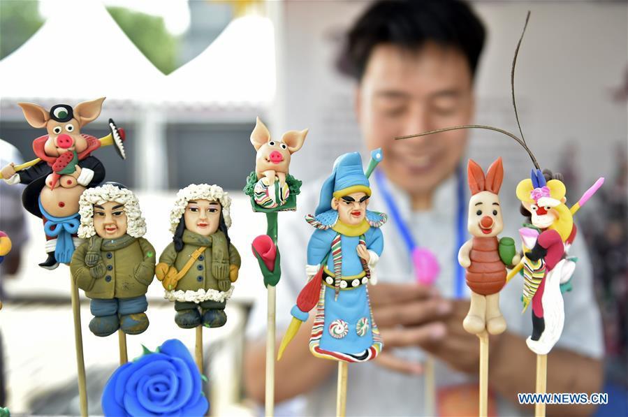 Folk artist Zhang Bin makes dough figurines in an intangible cultural heritage fair in Shenyang, capital of northeast China\'s Liaoning Province, June 9, 2018. Activities were held around China to celebrate the Cultural and Natural Heritage Day on Saturday. (Xinhua/Yao Jianfeng)