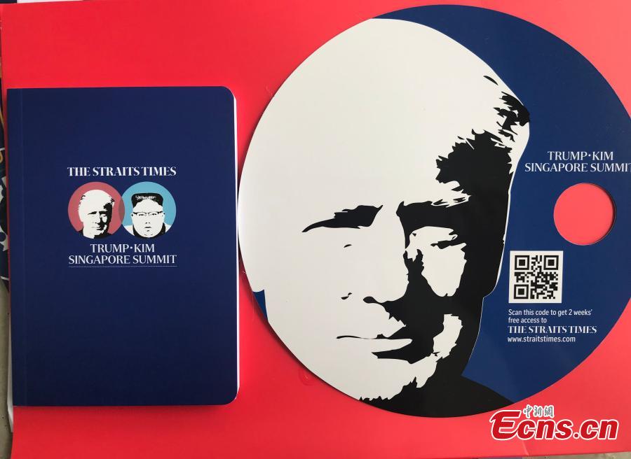 Souvenirs made for the DPRK-USA summit, including a notebook and a fan, are seen at the International Media Center at F1 Pit Building in Singapore, June 10, 2018. (Photo: China News Service/Meng Xiangjun)