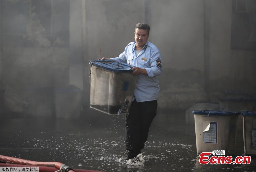 An official carries a ballot box, after a fire at a storage site in Baghdad, housing the boxes from Iraq\'s May parliamentary election, Iraq June 10, 2018. (Photo/Agencies)