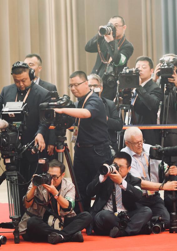 Journalists cover the SCO Qingdao Summit on Sunday. (Photo/China Daily)