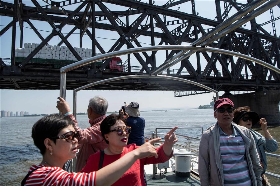 Tourists view the DPRK from the Yalu River in Dandong. (FRED DUFOUR/FOR CHINA DAILY)

Speculation

Zhang added that local people have not reacted to speculation in some parts of China that Dandong could be a future Shenzhen－the city in Guangdong province that was the country\'s first special economic zone. The speculation erupted after Kim announced plans to focus on economic development during a meeting in the DPRK on April 20.

\