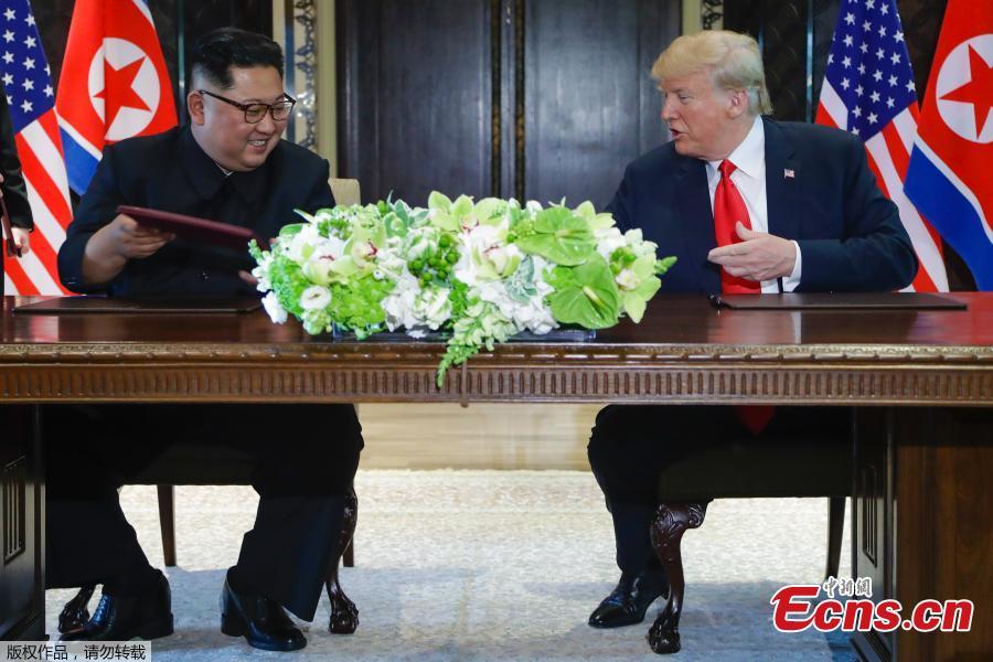 U.S. President Donald Trump (R) and top leader of the Democratic People\'s Republic of Korea (DPRK) Kim Jong Un sign documents that acknowledge the progress of the talks and pledge to keep momentum going, after their summit at the Capella Hotel on Sentosa island in Singapore, June 12, 2018. Trump said it is a \
