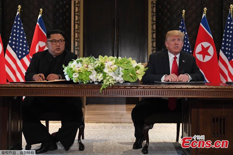 U.S. President Donald Trump (R) and top leader of the Democratic People\'s Republic of Korea (DPRK) Kim Jong Un sign documents that acknowledge the progress of the talks and pledge to keep momentum going, after their summit at the Capella Hotel on Sentosa island in Singapore, June 12, 2018. Trump said it is a \