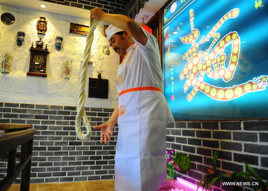 Quan Fujian pulls noodles at his restaurant in Yantai City, east China\'s Shandong Province, June 7, 2018. Fushan noodle is a traditional dish which is popular in Shandong Province. The noodle is hand pulled and cooked with various sauces and broths. The making of Fushan noodle was listed as a provincial intangible cultural heritage of Shandong in 2013. (Xinhua/Ren Pengfei)