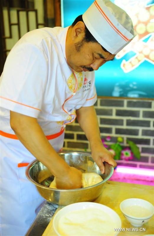 Quan Fujian prepares meals for customers at his restaurant in Yantai City, east China\'s Shandong Province, June 7, 2018. Fushan noodle is a traditional dish which is popular in Shandong Province. The noodle is hand pulled and cooked with various sauces and broths. The making of Fushan noodle was listed as a provincial intangible cultural heritage of Shandong in 2013. (Xinhua/Ren Pengfei)
