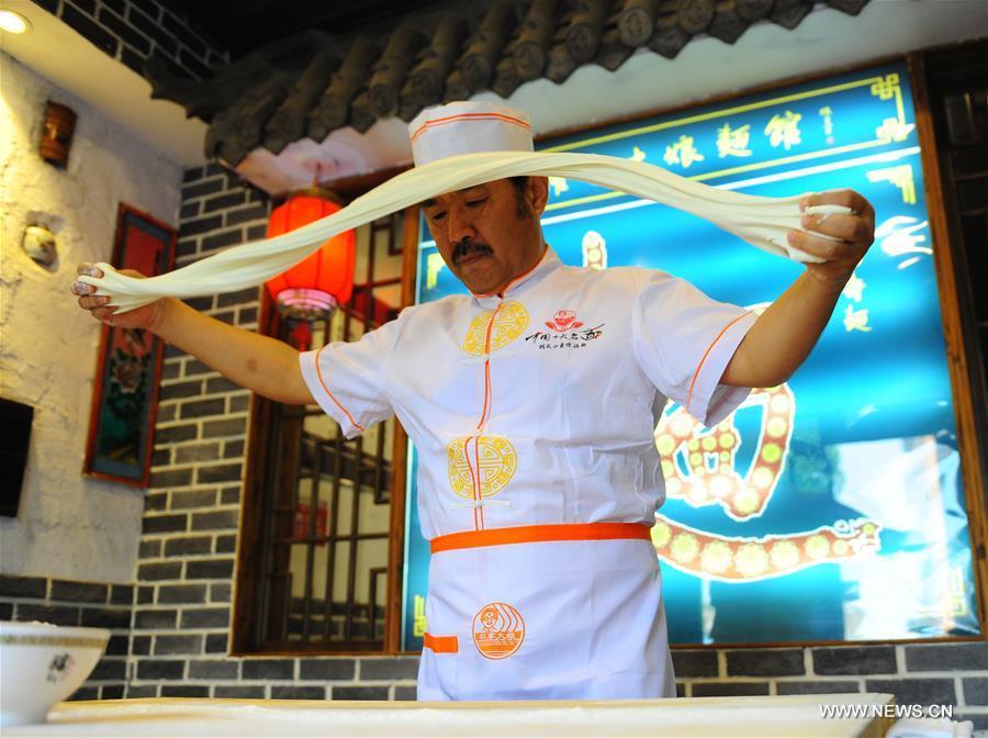 Quan Fujian pulls noodles at his restaurant in Yantai City, east China\'s Shandong Province, June 7, 2018. Fushan noodle is a traditional dish which is popular in Shandong Province. The noodle is hand pulled and cooked with various sauces and broths. The making of Fushan noodle was listed as a provincial intangible cultural heritage of Shandong in 2013. (Xinhua/Ren Pengfei)