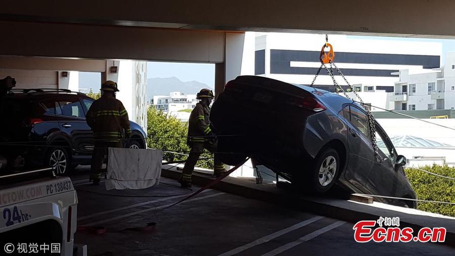 Photo taken on June 11, 2018 shows a tourist rescued a motorist whose car was left dangling off the fifth floor of a car park in Santa Monica, California. The female driver, reportedly in her 60s, came close to driving off the edge of the building after accidentally pushing the accelerator, local media reported. (Photo/Agencies)