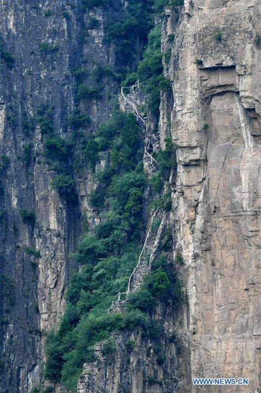 Photo taken on June 13, 2018 shows a flight of steps on cliffs used in the past by villagers to go to the county seat in Shenlongwan Village in Changzhi City, north China\'s Shanxi Province. A 1,526-meter-long road was built along the cliffs to connect isolated Shenlongwan to the outside. The construction of this miraculous road lasted for fifteen years from 1985 to 2000, and was built purely by villagers of Shenlongwan. Thanks to this road, villagers here now cast off poverty by developing tourism. (Xinhua/Cao Yang)