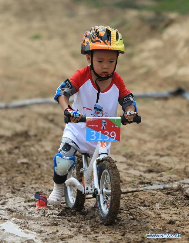 A child competes during a balance bike contest at a park in Gu\'an County, north China\'s Hebei Province, June 16, 2018. More than 300 children from Beijing, Tianjin and Hebei participated in the activity on Saturday. (Xinhua/Men Congshuo)