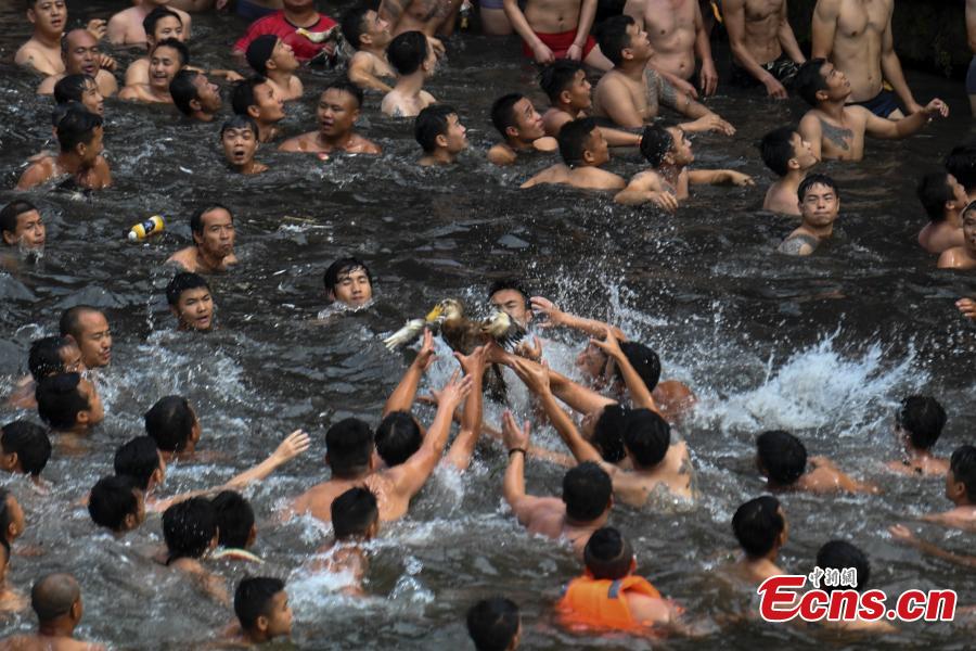 <?php echo strip_tags(addslashes(Participants compete to grab ducks during a folk event to celebrate the Dragon Boat Festival in the Tuojiang River in Phoenix Ancient Town, Central China’s Hunan Province, June 18, 2018. The duck-chasing tradition in the river has a 100-year history. (Photo: China News Service/Yang Huafeng))) ?>
