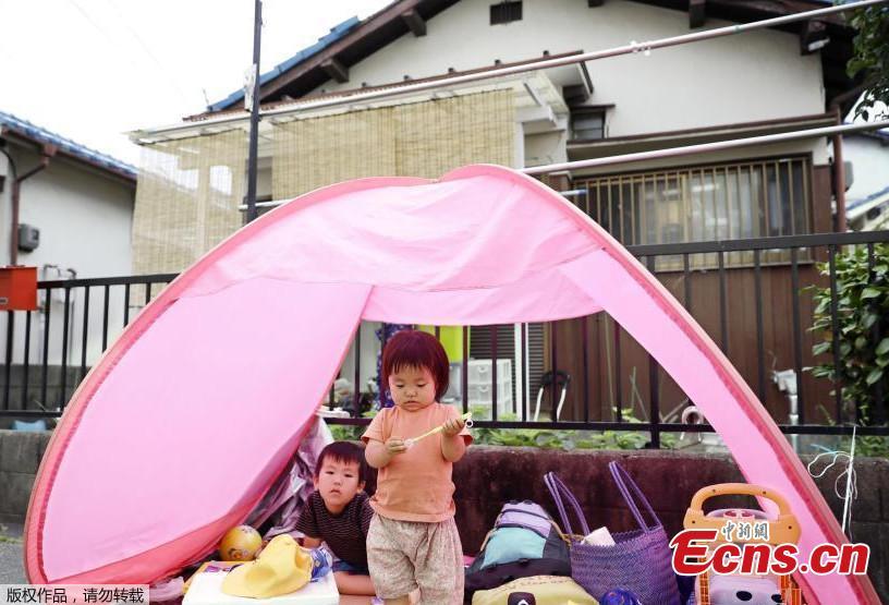Children evacuate to a temporary tent set up in the garden of their house in Ibaraki, after an earthquake shook Osaka, western Japan, June 18, 2018. A magnitude 6.1 earthquake shook Osaka, Japan’s second-biggest metropolis, early on Monday, killing three people, halting factory lines in an industrial area and bursting water mains, government and company officials said. (Photo/Agencies)