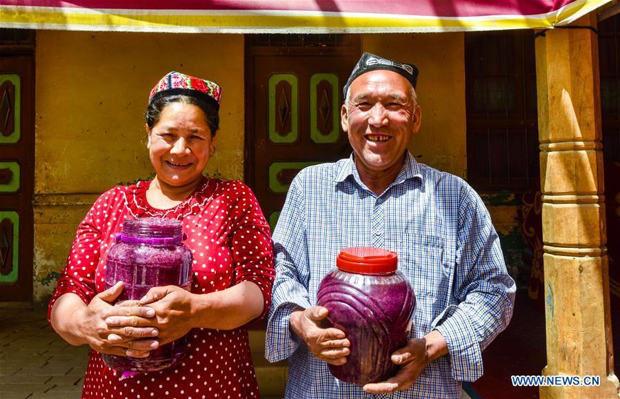 <?php echo strip_tags(addslashes(Flower grower Ruz and his wife Tajinisa show their handmade rose sauces at a village in Hotan, northwest China's Xinjiang Uygur Autonomous Region, June 6, 2018. People in the village are good at making rose sauce, and that is an important source of income for them. (Xinhua/Zhao Ge))) ?>
