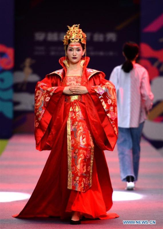 Models present creations during a fashion show in Xi\'an, capital of northwest China\'s Shaanxi Province, June 19, 2018. Both modern creations and traditional costumes of the Tang Dynasty (618-907) were presented in the show. (Xinhua/Liu Xiao)