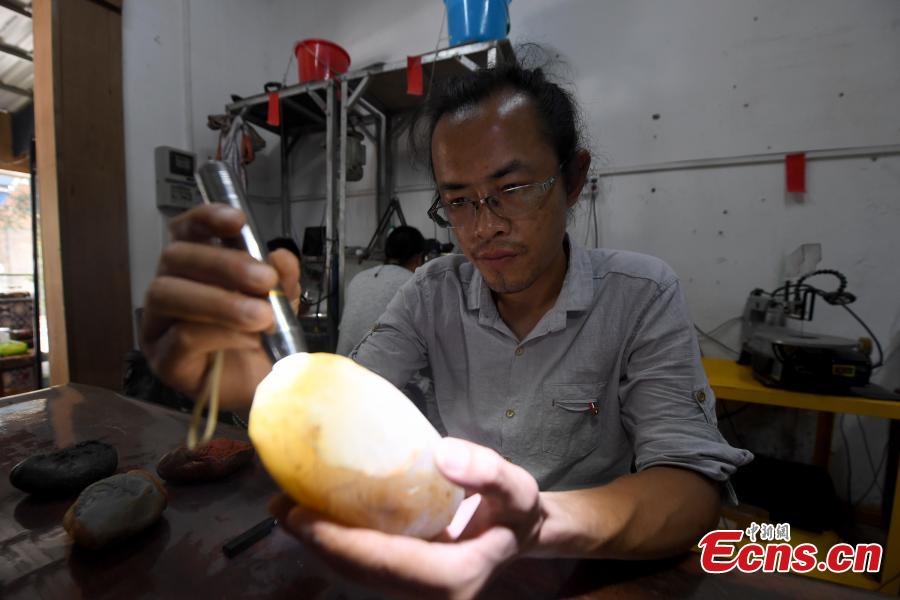 Jade carving craftsman Qian Siyu works in his studio in Nanning City, South China’s Guangxi Zhuang Autonomous Region, June 20, 2018. Qian, born in 1984, is known for combining the elements of the culture and traditions of the Zhuang ethnic group into his designs. (Photo: China News Service/Yu Jing)