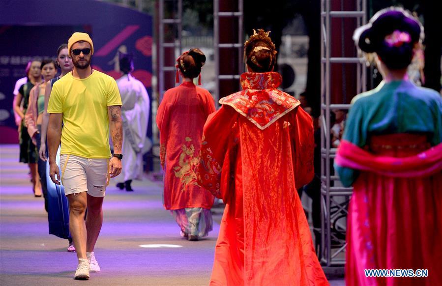 Models present creations during a fashion show in Xi\'an, capital of northwest China\'s Shaanxi Province, June 19, 2018. Both modern creations and traditional costumes of the Tang Dynasty (618-907) were presented in the show. (Xinhua/Liu Xiao)
