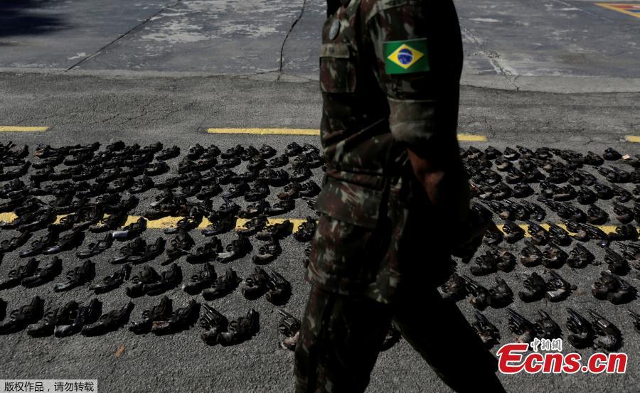 A Brazilian Army soldier walks past by guns seized from criminals by armed forces before being destroyed in Rio de Janeiro, Brazil, June 20, 2018. The Brazilian army invited the media Wednesday to observe the destruction of 8,549 firearms seized from criminals, handed in voluntarily, or retired from police arsenals. (Photo/Agencies)