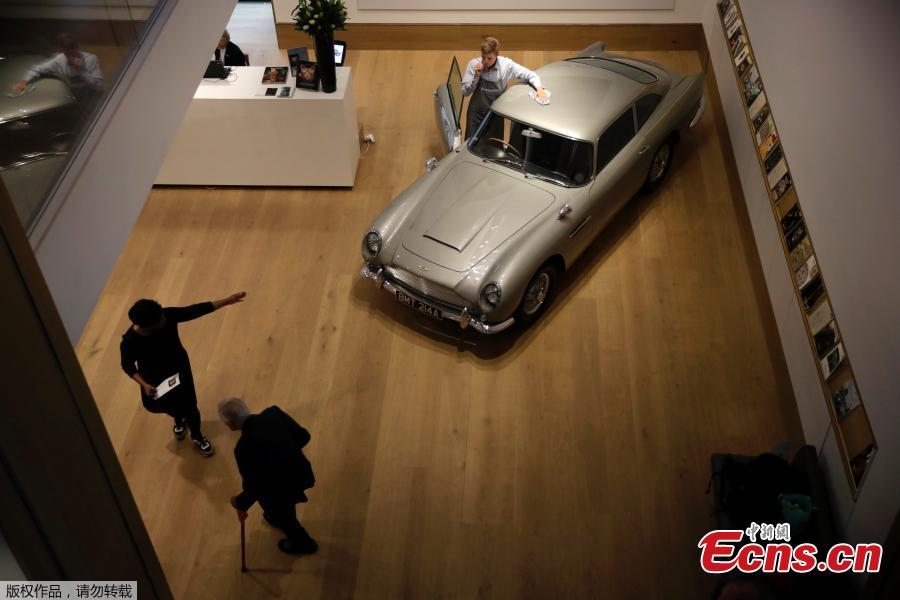 A staff member from the Bonhams motor car department poses for photographers with the 1965 Aston Martin DB5 driven by actor Pierce Brosnan in his role as James Bond in the 1995 movie GoldenEye during a photocall at premises of Bonhams auction house in London, June 19, 2018. The car is estimated to fetch between 1.2 million and 1.6 million pounds ($1.6 million to $2.1 million) in a sale on July 13. (Photo/Agencies)