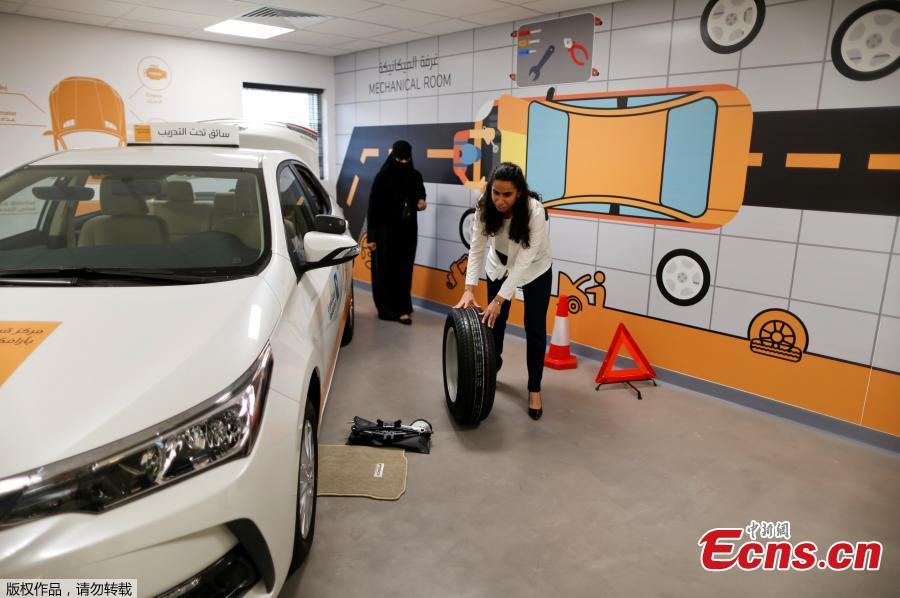 <?php echo strip_tags(addslashes(Trainee Maria al-Faraj practices how to adjust a tire during a driving lesson at Saudi Aramco Driving Center in Dhahran, Saudi Arabia, June 6, 2018. (Photo/Agencies))) ?>