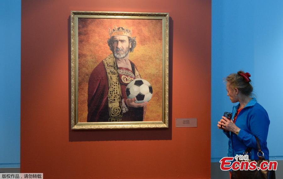 A visitor looks at a portrait of French football legend Eric Cantona as she attends the Art Project \'Like the Gods\', presented by the Museum of the Russian Academy of Arts and Italian artist Fabrizio Birimbelli during the FIFA World Cup of Russia 2018 in Saint Petersburg, on June 20, 2018. The project presents a series of portraits of world football stars and coaches in historical uniforms and includes more than 40 portraits. (Photo/Agencies)
