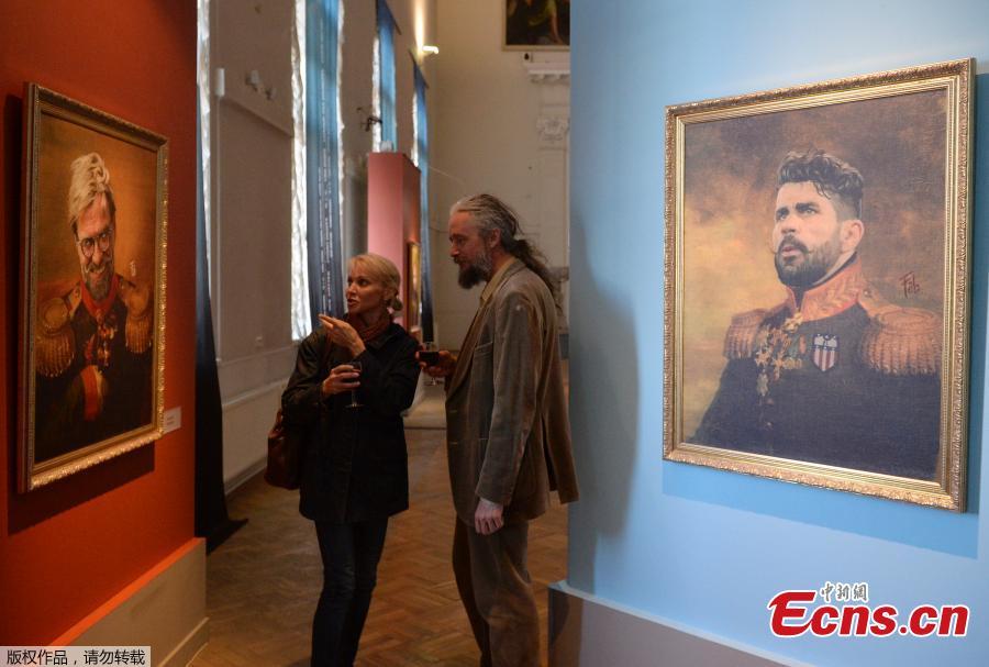 Visitors look at a portrait of Liverpool coach Juergen Klopp (L) as they attend during the Art Project \'Like the Gods\', presented by the Museum of the Russian Academy of Arts and Italian artist Fabrizio Birimbelli during the Russia 2018 World Cup in Saint Petersburg, on June 20, 2018. The project presents a series of portraits of world football stars and coaches in historical uniforms and includes more than 40 portraits. (Photo/Agencies)