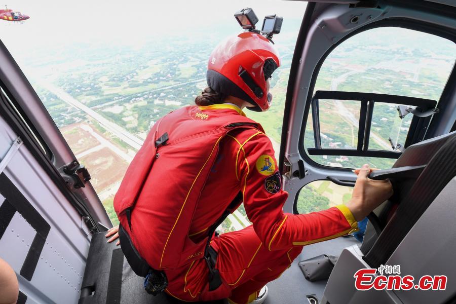 Shi Chunyan, a female BASE jumper, successfully jumps from a helicopter at a height of 300 meters at a theme park in Zhuzhou City, Central China’s Hunan Province, June 23, 2018. When the helicopter reached the planned height, she jumped off and landed safely using a parachute in the 60-second challenge. (Photo: China News Service/Yang Huafeng)