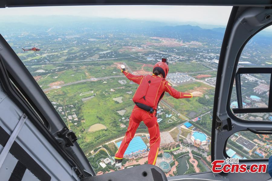 Shi Chunyan, a female BASE jumper, successfully jumps from a helicopter at a height of 300 meters at a theme park in Zhuzhou City, Central China’s Hunan Province, June 23, 2018. When the helicopter reached the planned height, she jumped off and landed safely using a parachute in the 60-second challenge. (Photo: China News Service/Yang Huafeng)