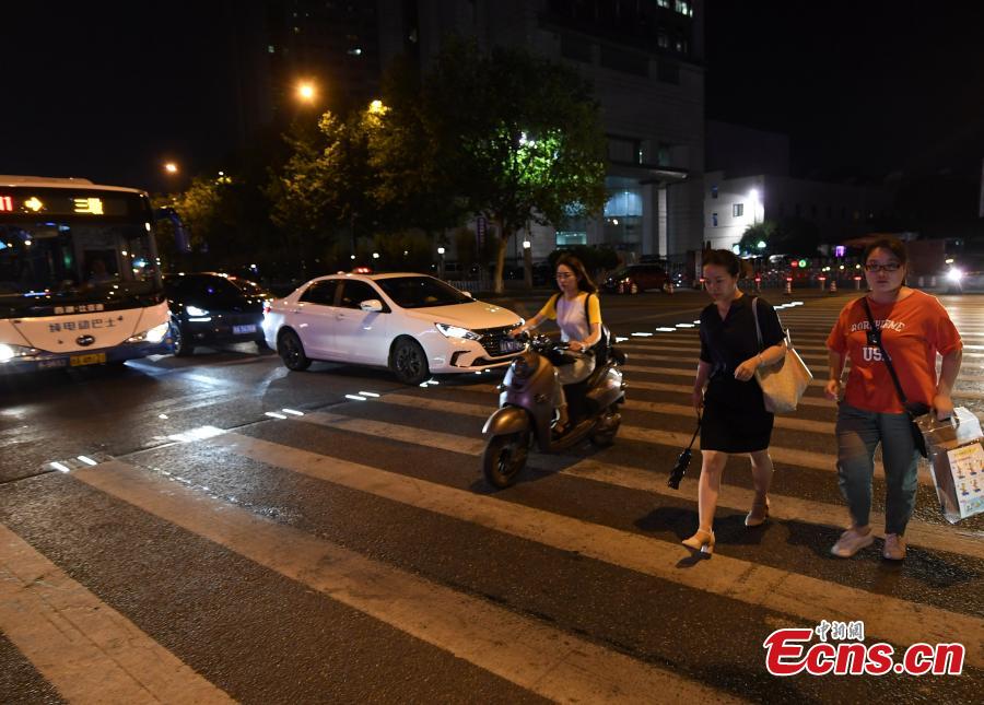 Lights on two sides of a zebra crossing on a street in Zhejiang Province will automatically light up when they sense pedestrians, reminding cars to slow down.
 (Photo: China News Service/Wang Gang)
