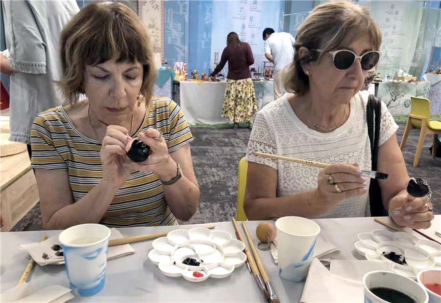 Local visitors learn to make gourd paintings under the guidance of folk artist Guan Hui in Tel Aviv, Israel, June 25, 2018. (Photo/Asianewsphoto)