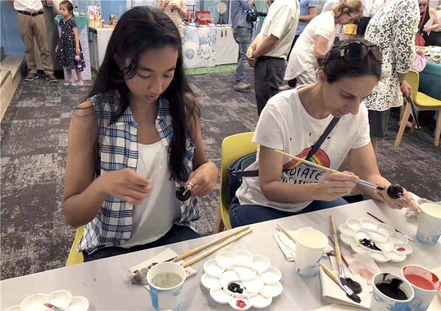 Local visitors learn to make gourd paintings under the guidance of folk artist Guan Hui in Tel Aviv, Israel, June 25, 2018. (Photo/Asianewsphoto)