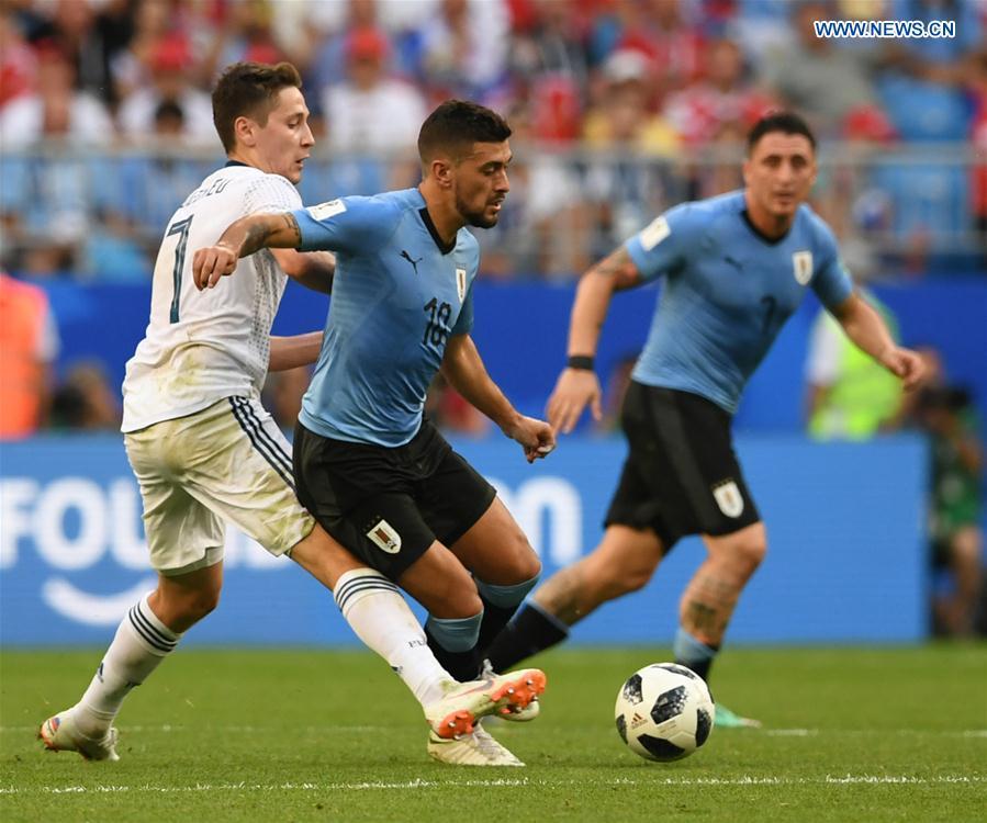 Giorgian De Arrascaeta (C) of Uruguay vies with Daler Kuziaev (L) of Russia during the 2018 FIFA World Cup Group A match between Uruguay and Russia in Samara, Russia, June 25, 2018. Uruguay won 3-0. Russia and Uruguay advanced to the round of 16. (Xinhua/Du Yu)