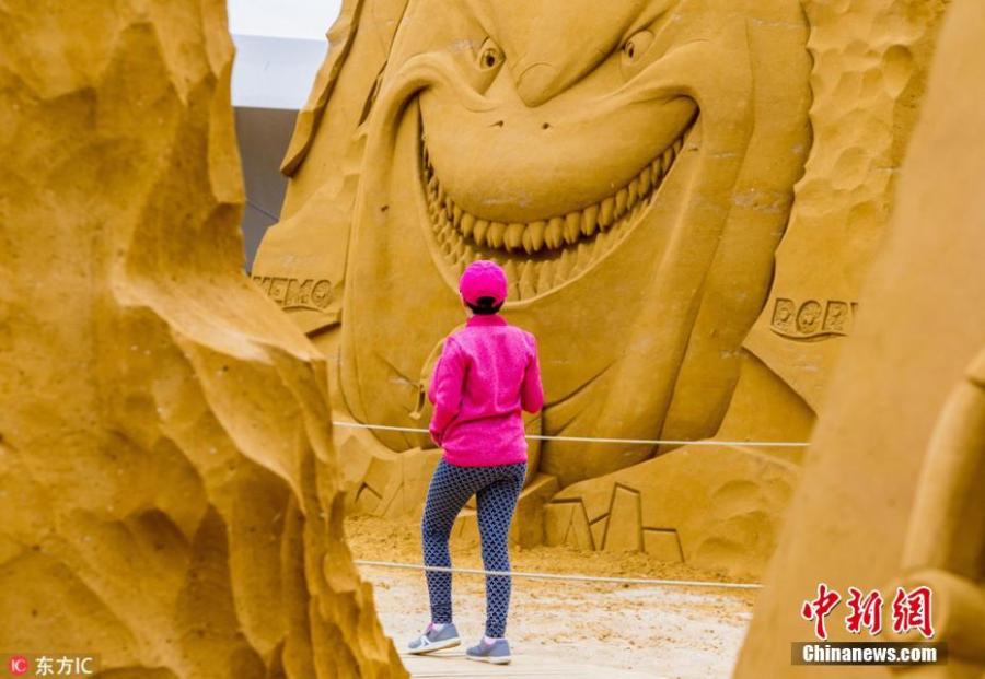 A visitor looks at a sculpture during the Sand Sculpture Festival \