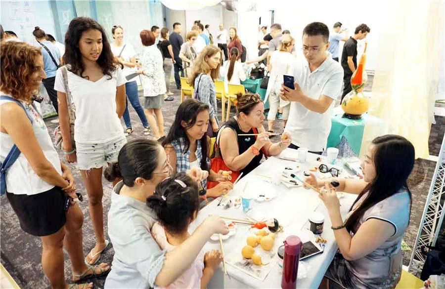 Chinese folk artist Guan Hui teaches visitors how to make gourd paintings in Tel Aviv, Israel, June 25, 2018.(Photo/Asianewsphoto)