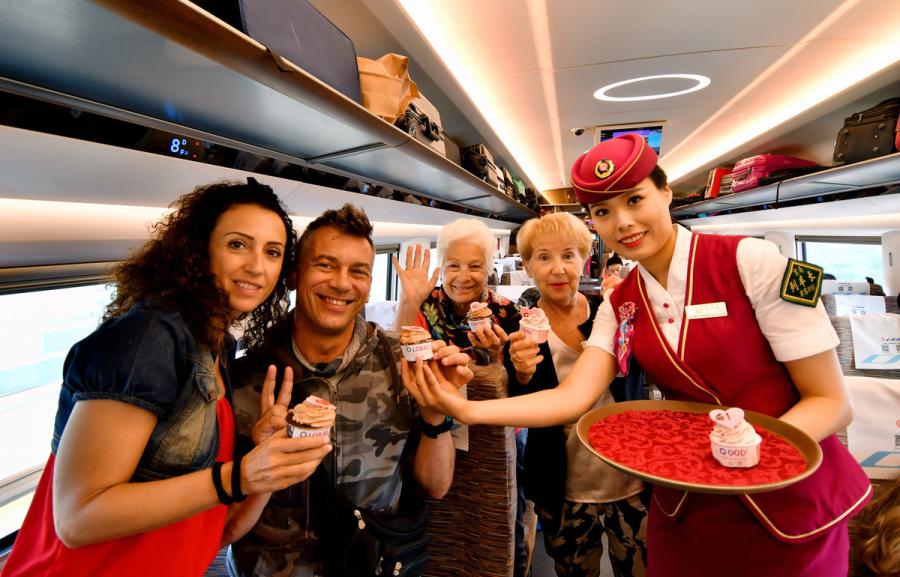 A steward hands out birthday cakes to passengers on the G1 Fuxing high-speed bullet train on Beijing-Shanghai high speed railway line on June 26, 2018. (Photo/Xinhua)
Fuxing high-speed bullet train celebrated its one-year anniversary on G1 high-speed railway line from Beijing to Shanghai on June 26, 2018.
Three new longer Fuxing bullet trains, with a designed speed of 350 kilometers per hour, will start to run on the Beijing-Shanghai line on July 1.
The Fuxing high-speed bullet trains are manufactured by China Railway Corporation and the technologies used on them play a leading role in the world. China owns complete intellectual property rights of these technologies.
Since starting operations on June 26, 2017, the popular bullet trains have provided wonderful experiences to the passengers.