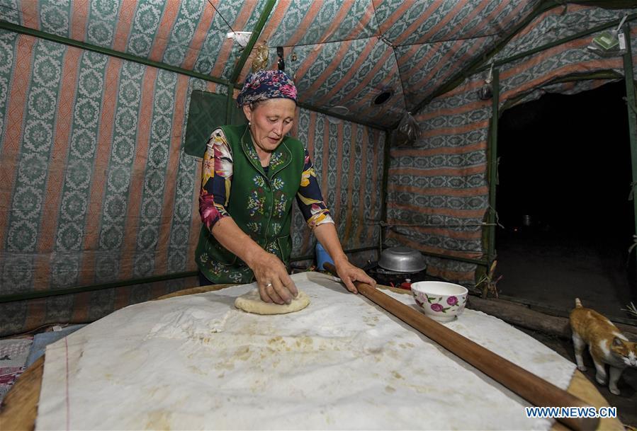 A herdswoman makes food in a yurt at the summer pasture on the Barlik Mountain in Yumin County, northwest China\'s Xinjiang Uygur Autonomous Region, June 23, 2018. Local herdsmen have transferred their livestock to summer pastures on the Barlik Mountain since late June and will stay here until September. Local authorities has devoted efforts in recent years to protect the ecological environment on the pasture and upgrade driveways to improve the infrastructure construction in the pasturing area. (Xinhua/Hu Huhu)