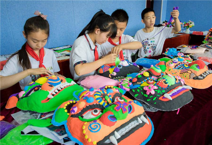 Students make auspicious beast masks at the Nanchafang Primary School in Hohhot, Inner Mongolia autonomous region, on June 27, 2018. (Photo/Asianewsphoto)