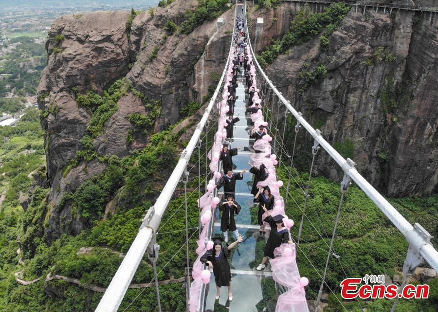 <?php echo strip_tags(addslashes(Students take creative graduation photos on a glass-bottom bridge in the Shiniuzhai National Geological Park in Pingjiang County, Central China's Hunan Province, June 27, 2018. The transparent bridge is suspended between two cliffs, 180 meters above ground. (Photo: China News Service/Yang Huafeng))) ?>