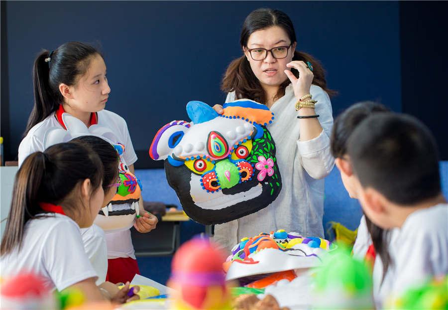 A teacher instructs students in making auspicious beast masks at the Nanchafang Primary School in Hohhot, Inner Mongolia autonomous region, on June 27, 2018. (Photo/Asianewsphoto)

Students from Nanchafang Primary School in Hohhot, Inner Mongolia autonomous region, learned to make a traditional auspicious beast mask under the guidance of teachers. They use super light clay to make a half-relief type lion mask, and got to know the cultural connotations of the craft, experiencing traditional culture directly.