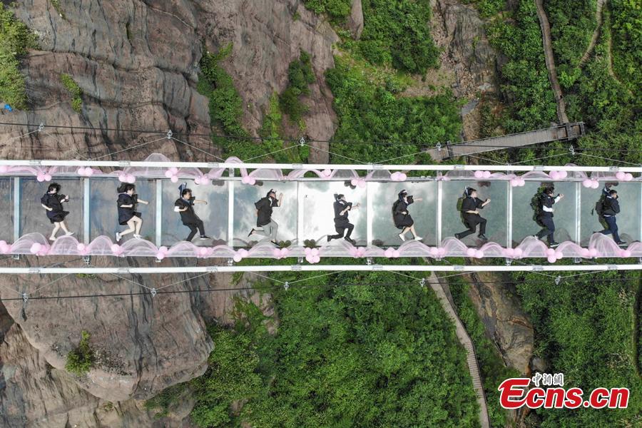 <?php echo strip_tags(addslashes(Students take creative graduation photos on a glass-bottom bridge in the Shiniuzhai National Geological Park in Pingjiang County, Central China's Hunan Province, June 27, 2018. The transparent bridge is suspended between two cliffs, 180 meters above ground. (Photo: China News Service/Yang Huafeng))) ?>
