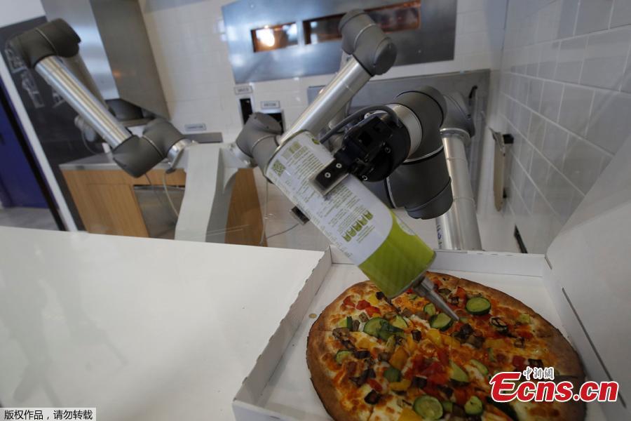 A pizzaiolo robot places a cooked pizza into its box before the customer’s eyes at the showroom of French food startup EKIM in Montevrain near Paris, France, June 26, 2018. Picture taken June 26, 2018. (Photo/Agencies)