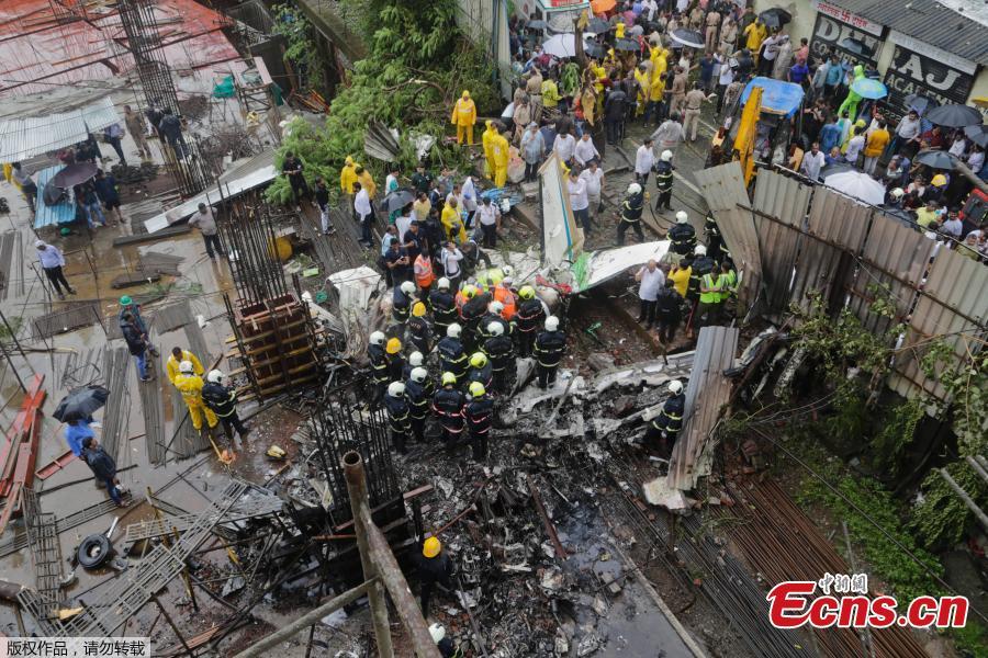 Rescuers stand amid the wreckage of a private chartered plane that crashed in Ghatkopar area, Mumbai, India, June 28, 2018. Five people including one person on the ground were killed. (Photo/Agencies)
