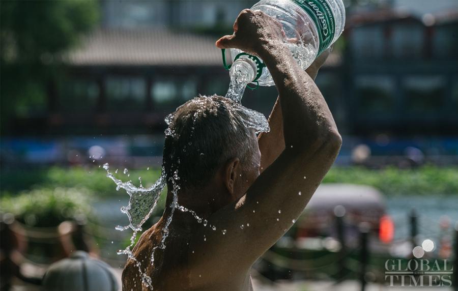 A man splashes himself to cool off during a heat wave in Beijing on Thursday. (Photo: Li Hao/GT)