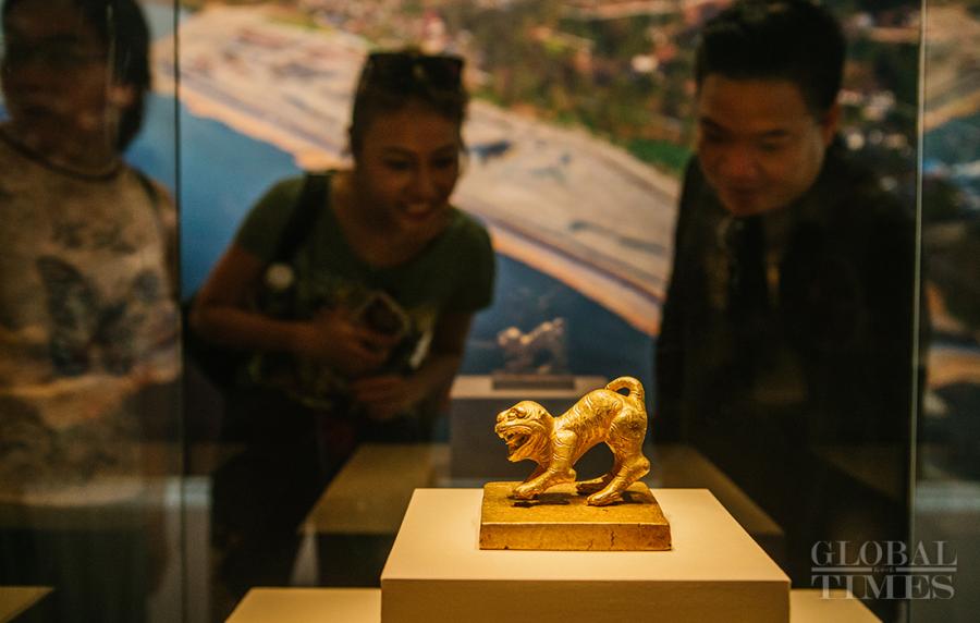 Visitors view a golden tiger-shape seal, a key find from the Jiangkou ruins. The bottom of the seal is carved with \
