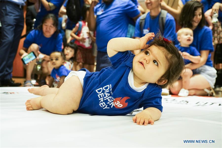 A baby participates in the Diaper Derby 2018 in New York, the United States, June 29, 2018. Diaper Derby 2018, a baby crawling contest, was held here on Friday. Around 30 babies competed to crawl across a 12-foot (3.66 meters) long mat. (Xinhua/Lin Bilin)